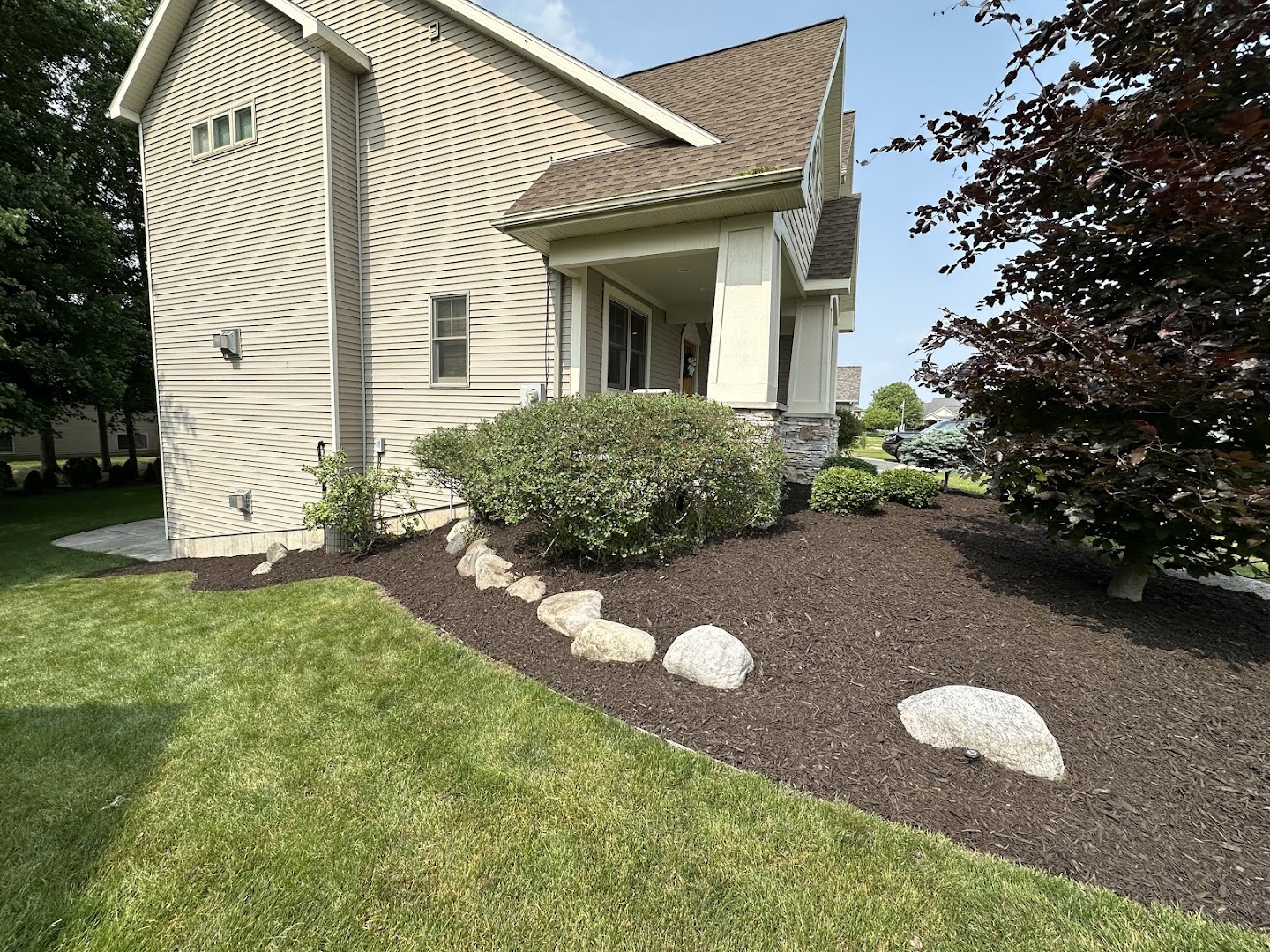 Front-yard mulch bed with boulders, Grand Rapids MI
